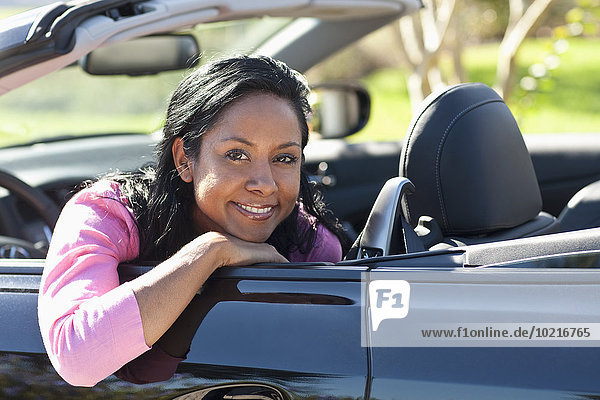 Indian woman smiling in convertible