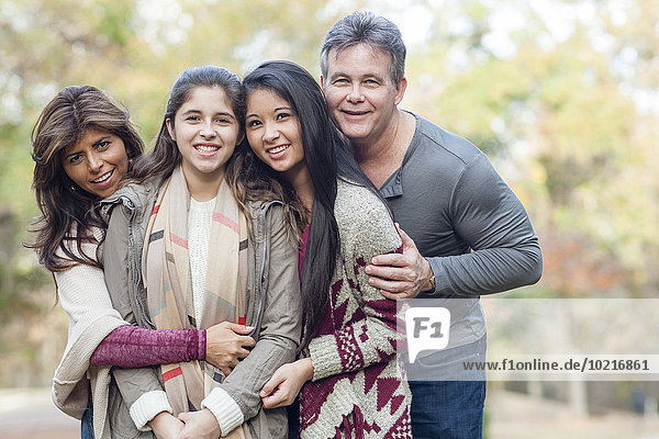 Hispanic family hugging outdoors