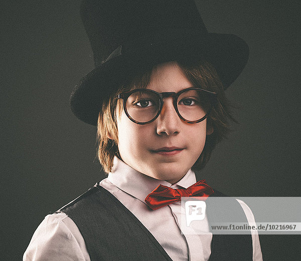 Close up of serious boy wearing top hat