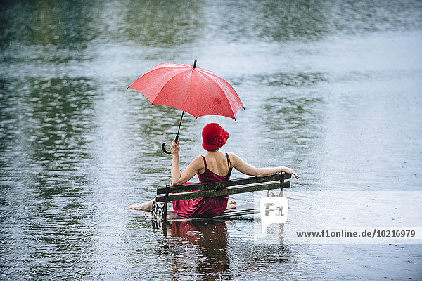 Caucasian woman sitting on bench in flood
