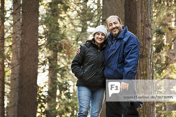 Hispanic couple hugging in forest