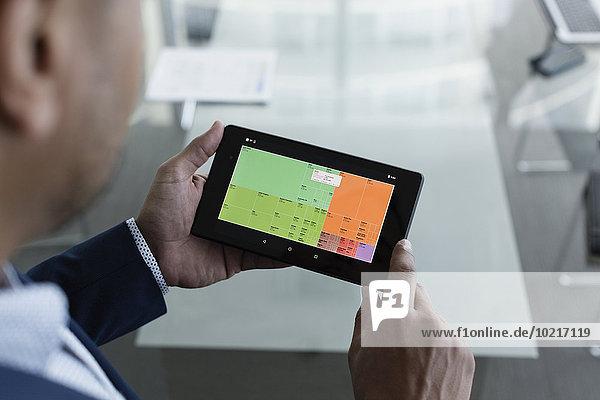 Hispanic businessman viewing graph on digital tablet