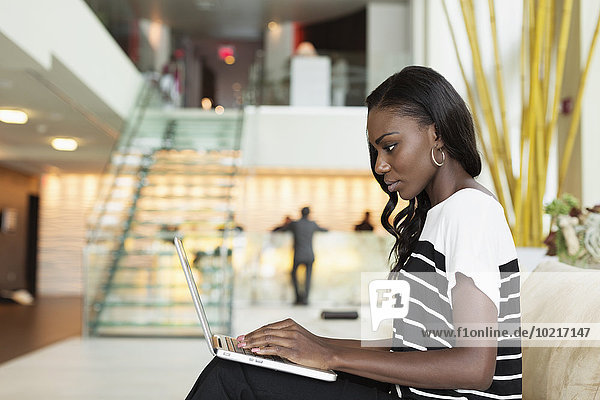 Businesswoman using laptop in hotel lobby