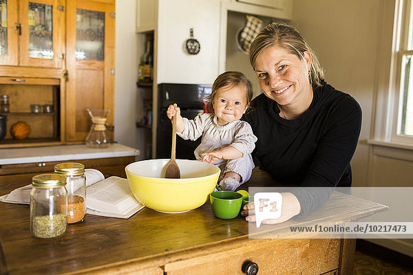 Caucasian mother and baby girl baking in kitchen