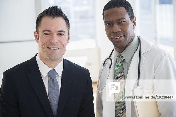 Businessman and doctor smiling in office