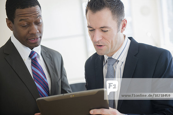 Businessmen using digital tablet in office