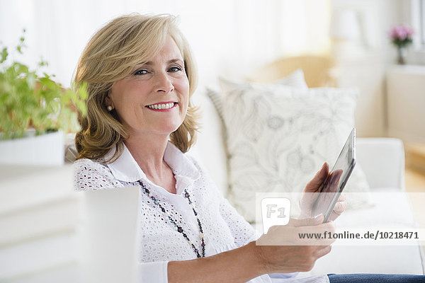 Caucasian woman using digital tablet on sofa