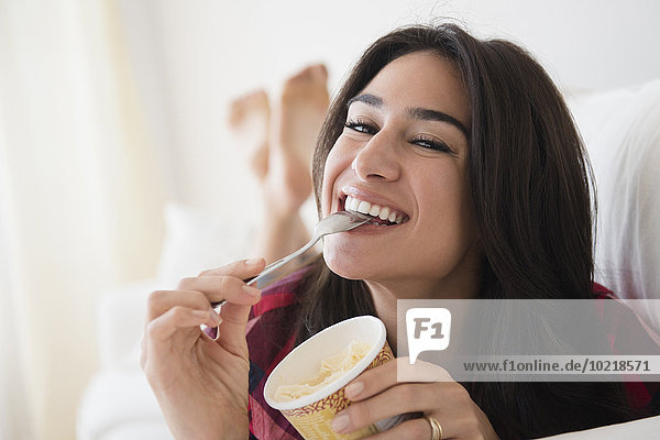 Close up of woman eating ice cream on sofa