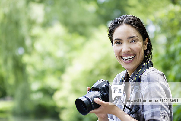 Hispanic woman photographing outdoors