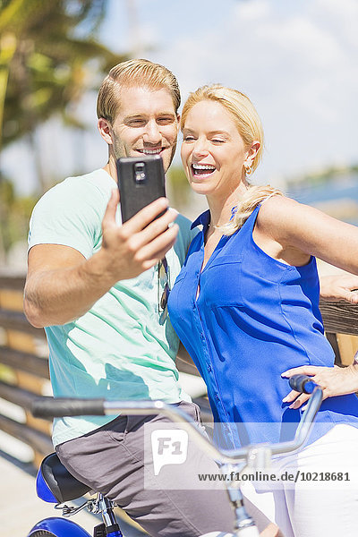 Caucasian couple taking selfie with cell phone