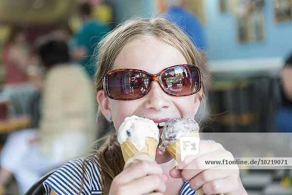 Caucasian girl eating two ice cream cones
