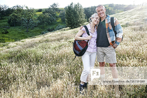 Caucasian couple smiling on hillside
