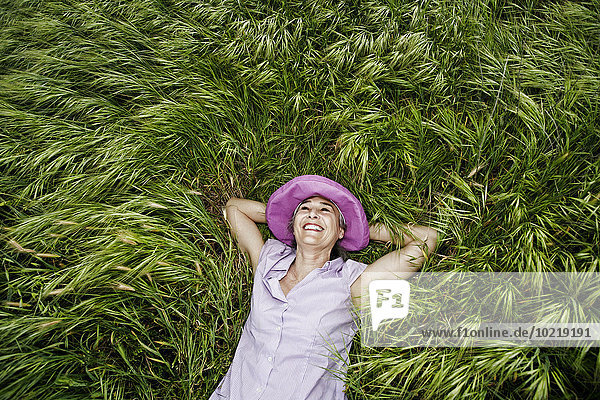 Caucasian woman laying in tall grass