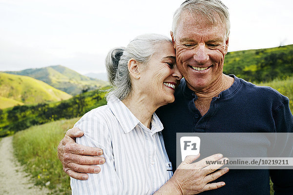 Caucasian couple hugging on hiking trail