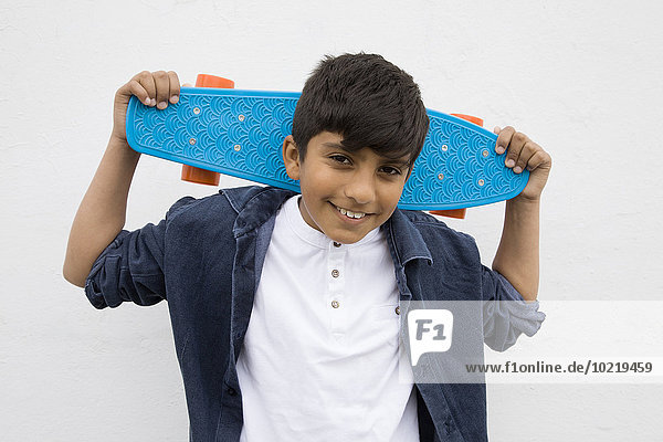 Asian boy holding skateboard