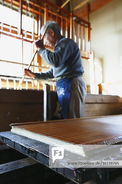 Japanese traditional paper craftsman working in his studio