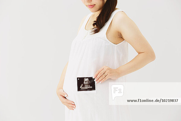 Young Japanese pregnant woman with ecography picture