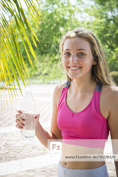 Mexiko Nayarit Porträt eines lächelnden Teenagers mit Wasserflasche