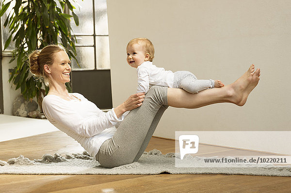 Woman balancing baby on her legs