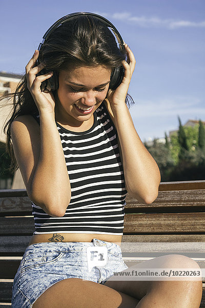Smiling teenage girl hearing music with headphones