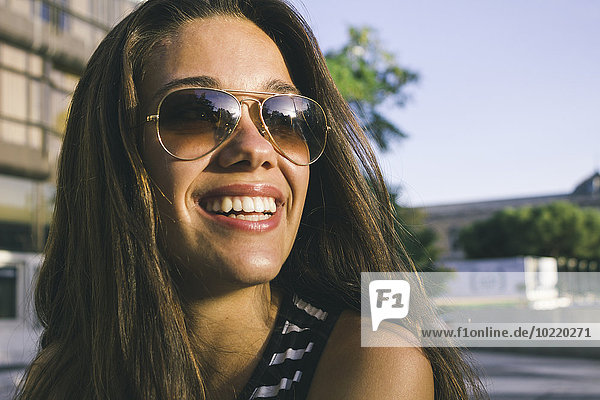 Porträt eines lächelnden Mädchens mit Sonnenbrille