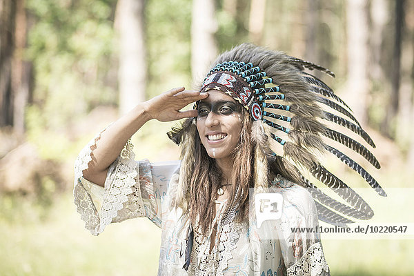 Porträt einer lächelnden jungen Frau als Indianerin verkleidet