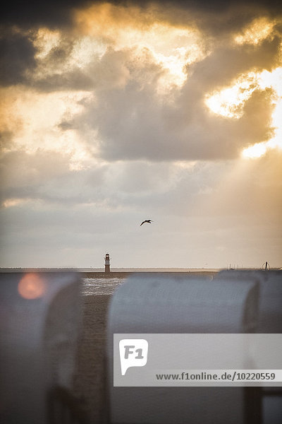 Deutschland Mecklenburg-Vorpommern Warnemünde Liegestühle am Strand bei Sonnenuntergang