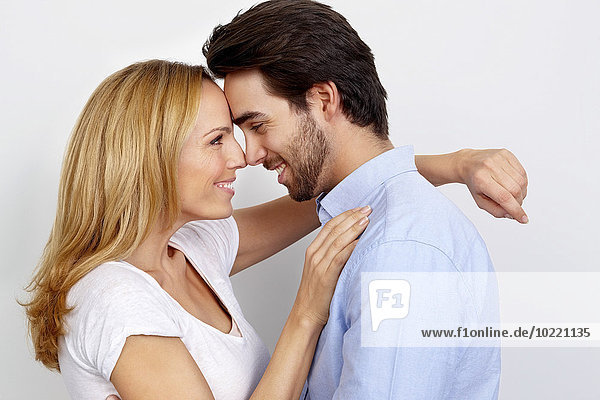 Portrait of loving couple in front of white background