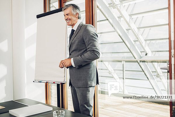 Mature businessman giving presentation in office