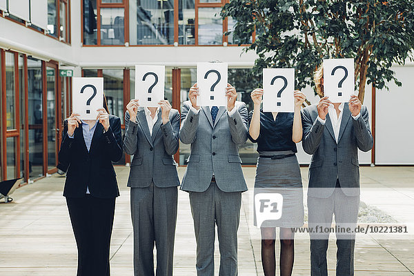 Business people with question mark on placards