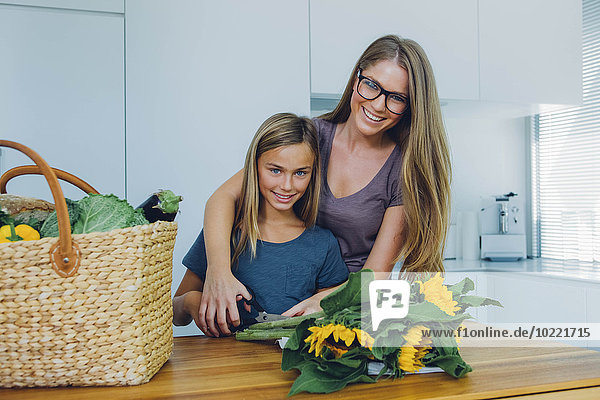Mutter und Tochter in der Küche schneiden Sonnenblumen