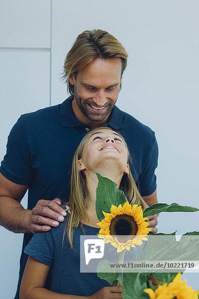 Lächelnder Vater und Tochter mit Sonnenblume