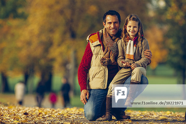 Portrait of little girl with her father in an autumnal park