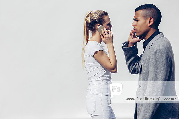 Two young people telephoning with smartphones