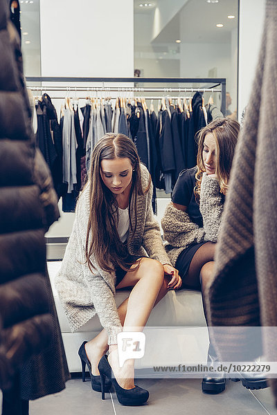Zwei junge Frauen beim Schuhkauf in einer Boutique