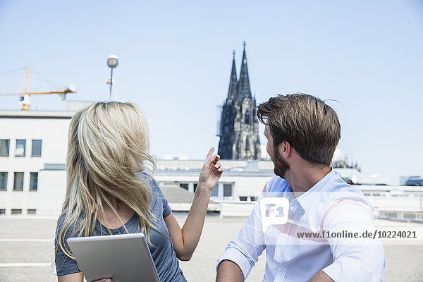 Germany  Cologne  young couple with digital tablet looking at Cologne Cathedral