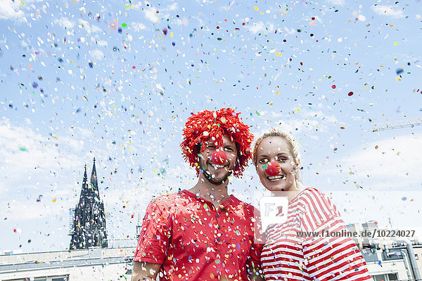 Germany  Cologne  young couple celebrating carnival dressed up as clowns