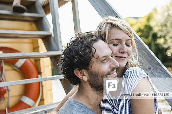 Ein glückliches Paar  das sich auf einem Hausboot umarmt.