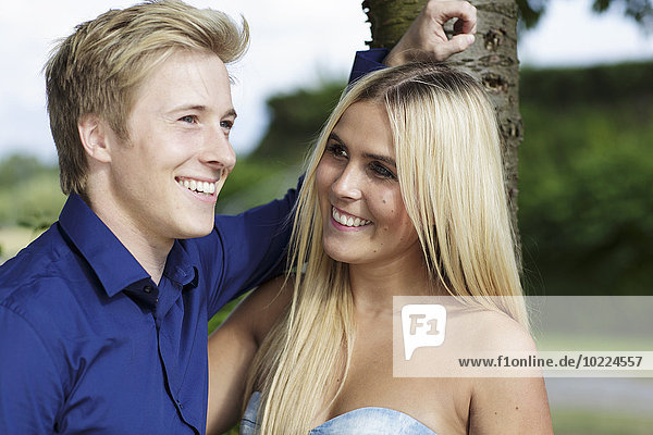 Smiling young couple at tree