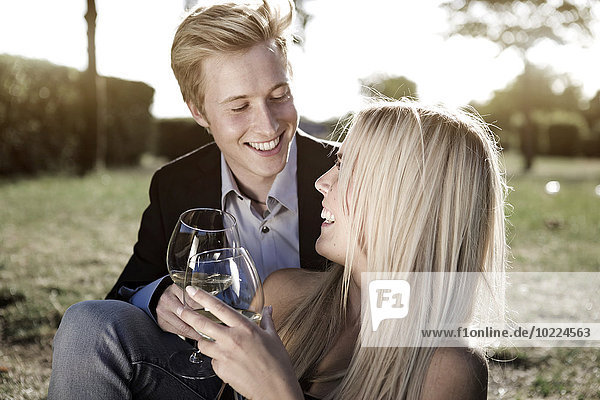 Elegantes junges Paar im Freien beim Weintrinken