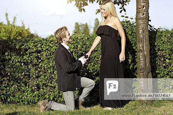 Young man proposing marriage to young woman