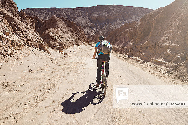 Chile  Man riding a mountain bike through the Valle de la Muerte  Atacama Desert