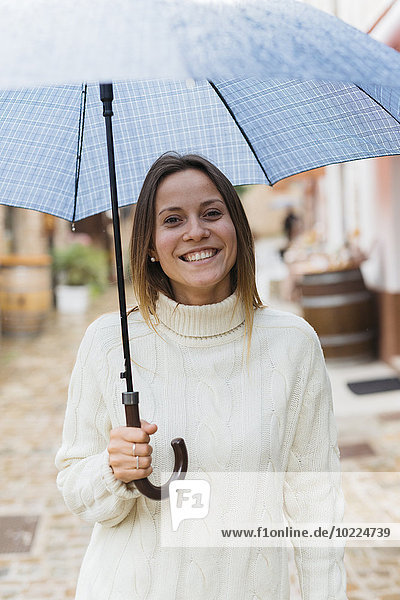 Italy  San Gimignano  portrait of smiling young woman with umbrella