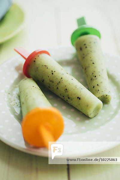 Drei Kiwi-Bananenpops auf einem Teller
