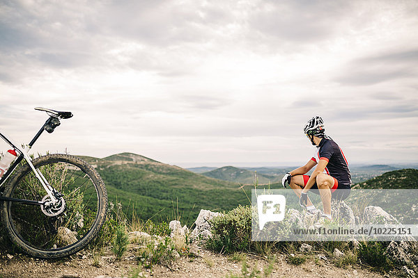 Spanien  Tarragona  Mountainbiker bei einer Pause im extremen Gelände