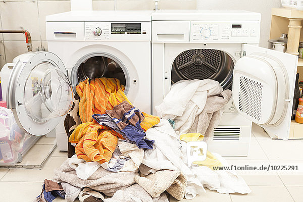 Schmutzige Wäsche  die aus Waschmaschine und Wäschetrockner fließt