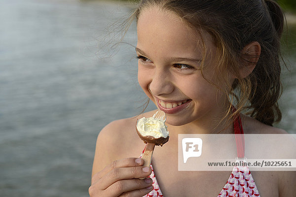 Porträt eines lächelnden Mädchens mit Eis am Stiel