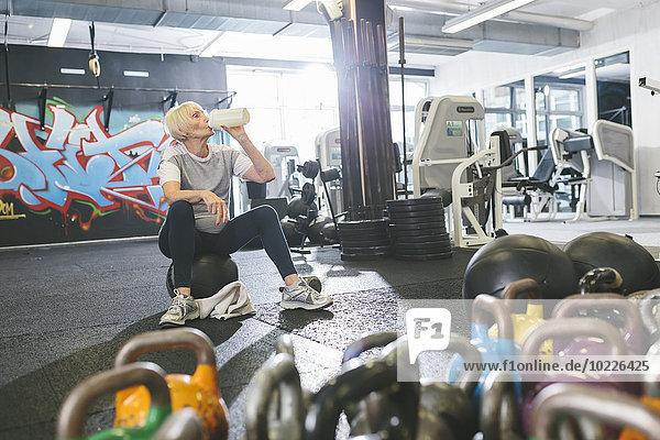 Senior woman in gym having a break