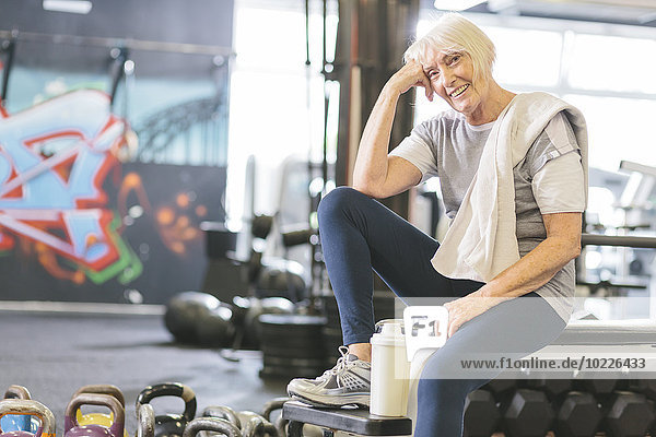 Smiling senior woman in gym having a break