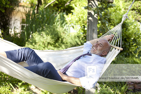 Geschäftsmann entspannt in der Hängematte im Garten